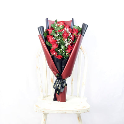 This bouquet includes a selection of deep red roses, baby's breath, and ruscus gathered in floral wrap with designer ribbon.